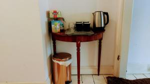 uma pequena mesa com comodidades para preparar café em Racecourse room in Cheltenham with bathroom access. em Cheltenham