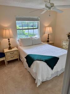 a bedroom with a large white bed with two lamps at Stunning 2-Bd Condo Naples, 55+, pool, Chickee, golf in Naples