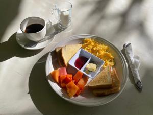 un piatto di prodotti per la colazione con una tazza di caffè di Hotel Posada Gutierrez a Panajachel