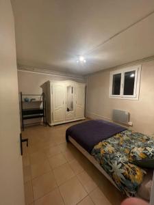 ein Schlafzimmer mit einem Bett und Fliesenboden in der Unterkunft Appartement indépendant en RDC in Lannemezan