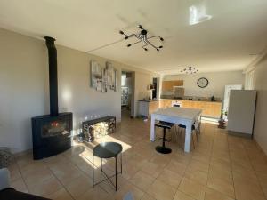 a living room with a table and a fireplace at Appartement indépendant en RDC chez habitant in Lannemezan