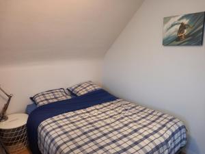 - une chambre avec un lit et une photo sur le mur dans l'établissement Maison Guidel Plages 4 à 8 personnes, à Guidel