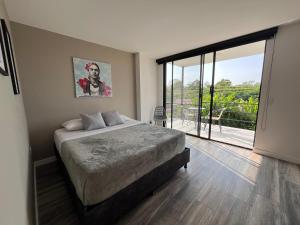 a bedroom with a large bed and a large window at Mestiza Hospedaje familiar in Quimbaya
