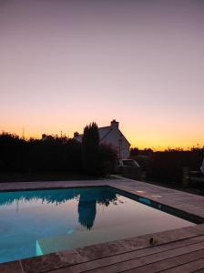 - un coucher de soleil sur la piscine au coucher du soleil dans l'établissement Maison Guidel Plages 4 à 8 personnes, à Guidel