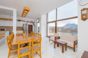 uma cozinha e sala de jantar com uma mesa de madeira e cadeiras em Къщата на Mечтите / House of the Dreams em Apriltsi