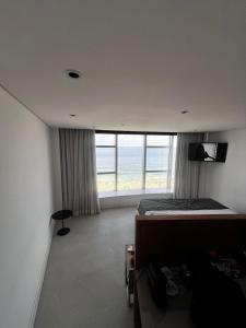 a bedroom with a bed and a view of the ocean at Hotel Nacional Apart Lux 1 in Rio de Janeiro