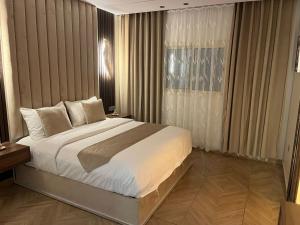 una camera con un grande letto e una finestra di Nourth House ApartHotel a Al Qurayyat