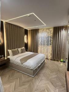 - une chambre avec un grand lit et une grande fenêtre dans l'établissement Nourth House ApartHotel, à Al Qurayyat