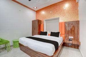 een slaapkamer met een groot bed met een oranje muur bij jsb hotel in Kakarmatha