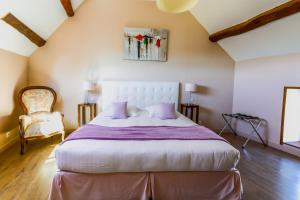 a bedroom with a large bed and a chair at La Villa Bel Air in Flamanville