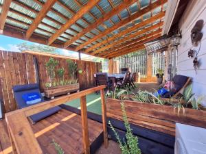 una terraza al aire libre con pérgola de madera en Windsong Living Tree Living en Krugersdorp