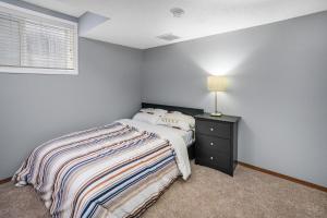 a bedroom with a bed and a lamp on a night stand at Cozy 2-Bedroom Basement Suite Retreat Calgary in Calgary