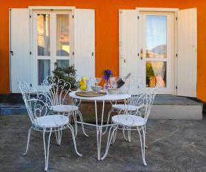 a white table and chairs in front of a building at Lake view 14 in Pisogne