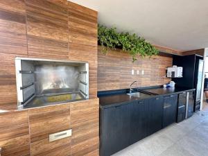 a kitchen with a sink and a counter with a fireplace at Edificio Nau no coração da Barra in Salvador