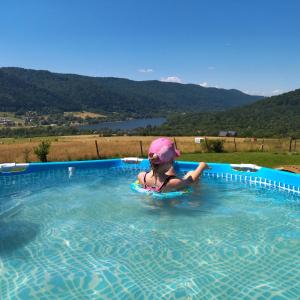 una niña en una piscina con casco en ORLIK - pokoje gościnne, en Uście Gorlickie