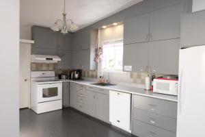 a kitchen with white cabinets and white appliances at Auberge Mélilot in Dolbeau