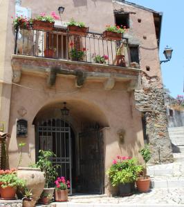 ein Gebäude mit einem Balkon mit Blumen darauf in der Unterkunft Al Borgo Antico in Forza dʼAgro