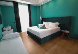 佩斯卡拉的住宿－Aron Only Suites Bed and Breakfast，一间卧室设有一张大床和蓝色的墙壁