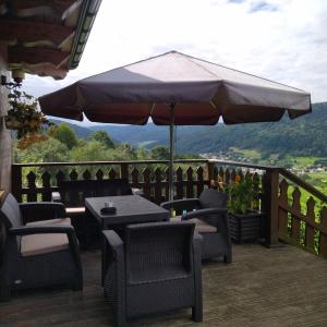 patio ze stołem, krzesłami i parasolem w obiekcie ORLIK - pokoje gościnne w mieście Uście Gorlickie