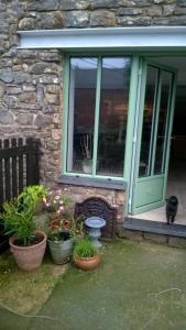 a house with a green door and some potted plants at La grange aux dîmes in Walcourt