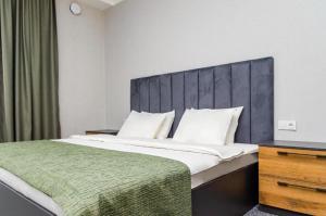 a bedroom with a large bed with a gray headboard at Dosman Hotel Bishkek in Bishkek +62 photos