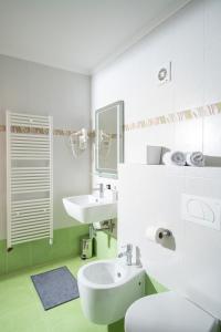 Baño blanco con lavabo y aseo en Humagum Sea View Apartment - Garden Palace Umag, en Umag