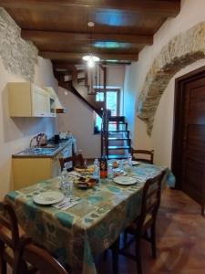 L'Arco Antico في Casalbuono: مطبخ وغرفة طعام مع طاولة وكراسي