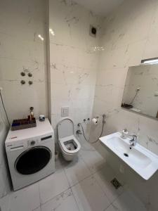 a white bathroom with a toilet and a sink at Stan na dan Sarajevo in Sarajevo