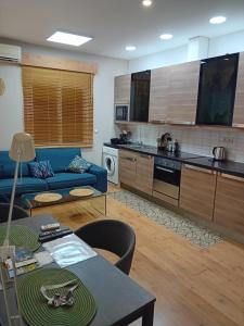 a living room with a blue couch and a kitchen at Bonavista Montgat in Montgat