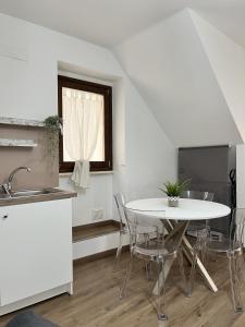cocina blanca con mesa, sillas y ventana en Stanze Borgo Antico, en Montenero di Bisaccia