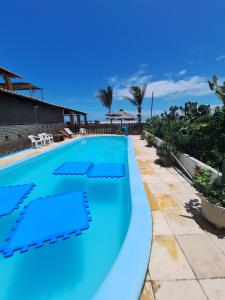 a swimming pool with blue water in a resort at Pousada Por do Sol in Barra Nova