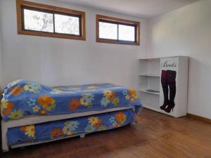 - une chambre avec un lit et une couverture bleue dans l'établissement Agradable Casa a Orillas del Lago Rapel, à Las Cabras