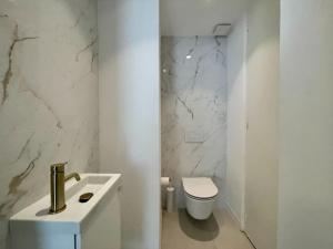 a white bathroom with a toilet and a sink at Appartement Centre Cannes in Cannes