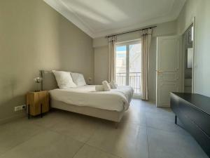 a bedroom with a bed and a large window at Appartement Centre Cannes in Cannes