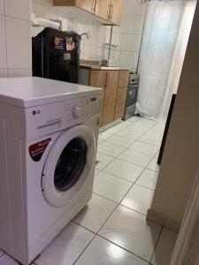 a white washing machine sitting in a kitchen at Studio Apartment in Sharjah
