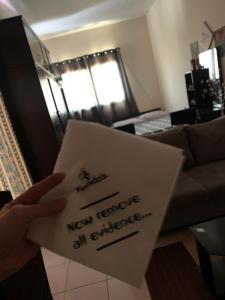 a hand holding a piece of paper with the words new temple an exchange at Studio Apartment in Sharjah