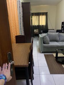 a living room with a table and a couch at Studio Apartment in Sharjah