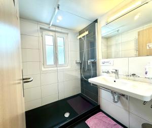 a bathroom with a sink and a shower at Haus Chalet Arnika in Saas-Grund