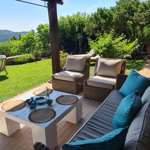 um pátio com um sofá, 2 cadeiras e uma mesa em Villa Emerald em Porto Cervo