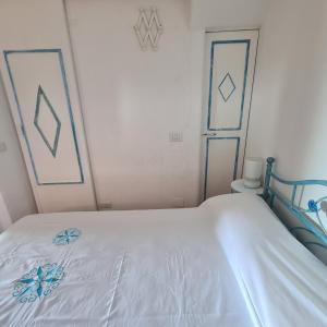 uma cama branca num quarto com duas fotografias na parede em Villa Emerald em Porto Cervo