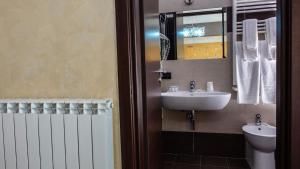 La salle de bains est pourvue d'un lavabo et d'un miroir. dans l'établissement Hotel Miramonti, à Gangi