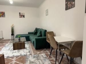 a living room with a green couch and a table at NDL Downtown in Cluj-Napoca