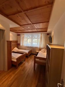a room with two beds and a window at Alpenhostel "Das Besenhaus" in Altenmarkt im Pongau