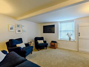 a living room with two chairs and a couch and a window at 2 Bed in Great Walsingham 90535 in Little Walsingham