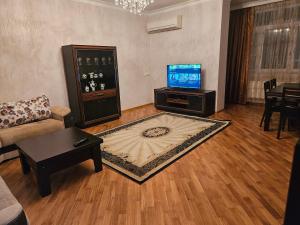 a living room with a couch and a tv at Parkview Family Apart in Baku
