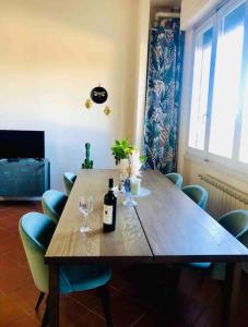 a wooden table with a bottle of wine and wine glasses at La casa di Nina in Montespertoli