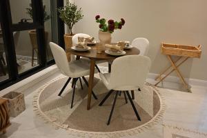 a dining room table with white chairs and a table with flowers at Damas Resort in Mezairaa