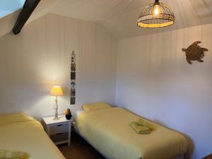 a bedroom with two beds and a lamp and a light at Maison de centre-village "Au bord de l'Ô" - Jardin - Parking in Cormeilles