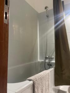 a bathroom with a white tub and a shower at Olimar Sea View Apartment in Albufeira