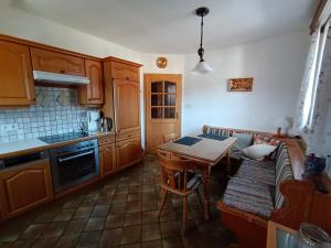 a kitchen with wooden cabinets and a table and a couch at Ferienwohnung Jaga in Rattendorf